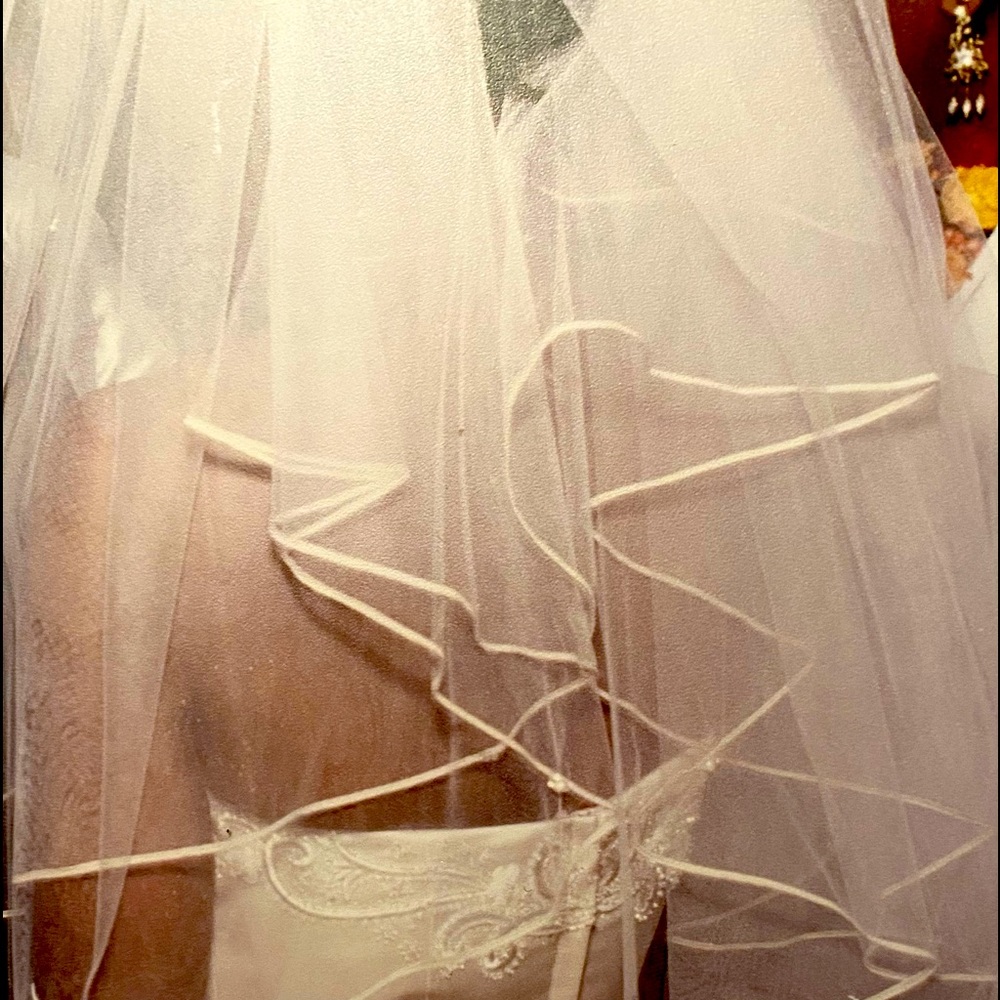 Off-white wedding dress with detachable train and veil.